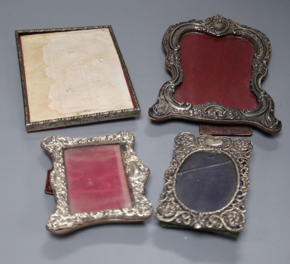 Two late Victorian silver mounted photograph frames, largest 20.3cm, a similar Edwardian frame and a later frame.